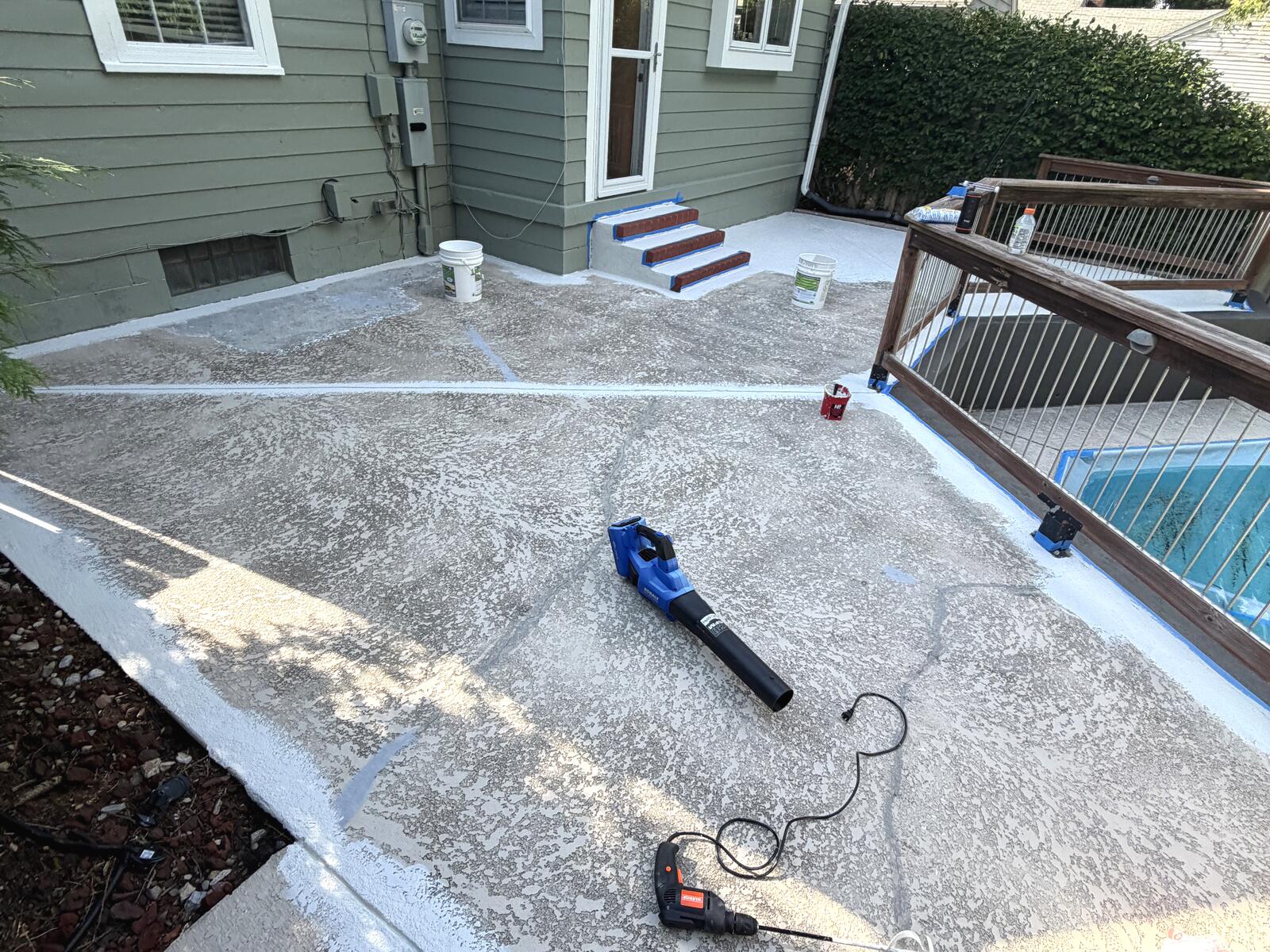 First coat being rolled onto the concrete patio